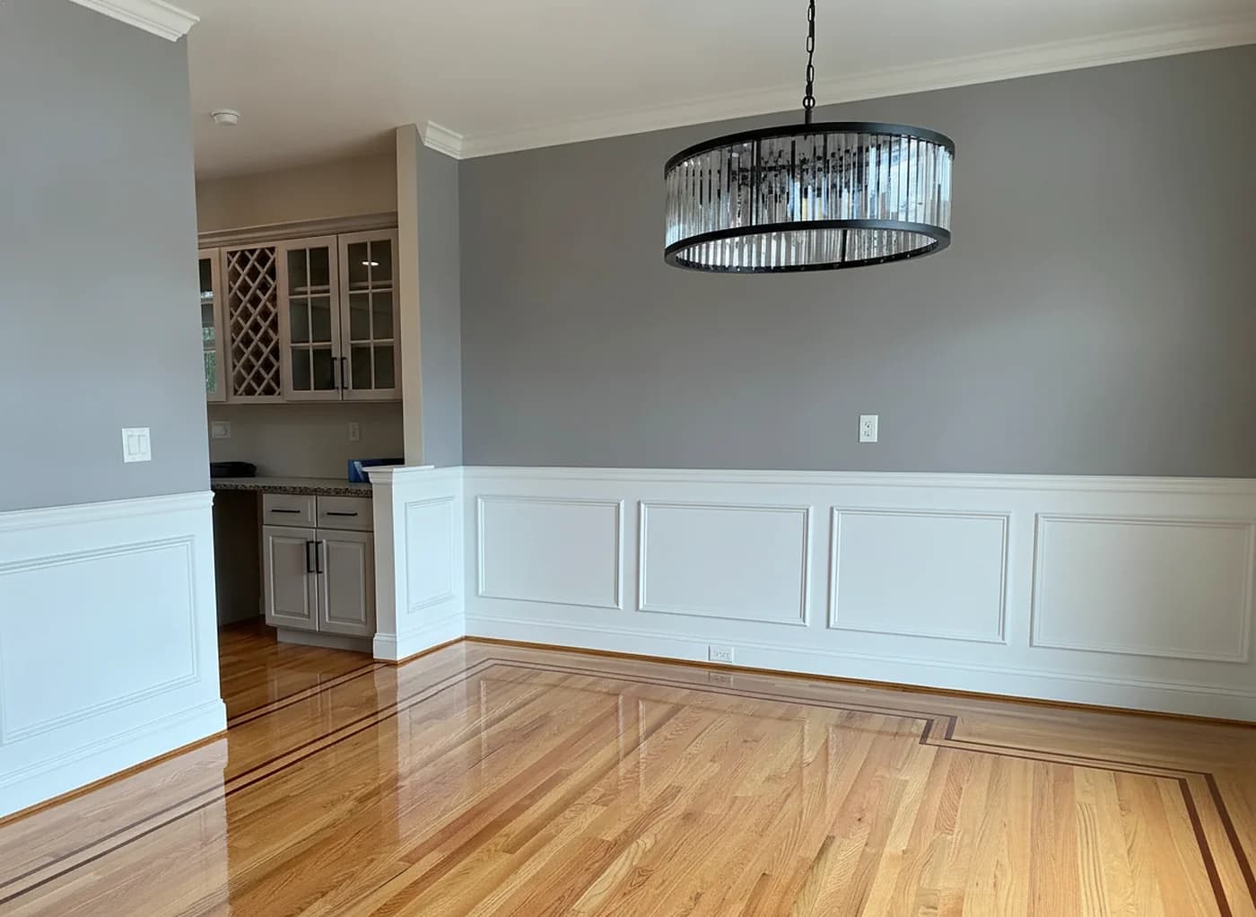 Refinished oak floor with wainscoting and chandelier in a Fairfield County dining room