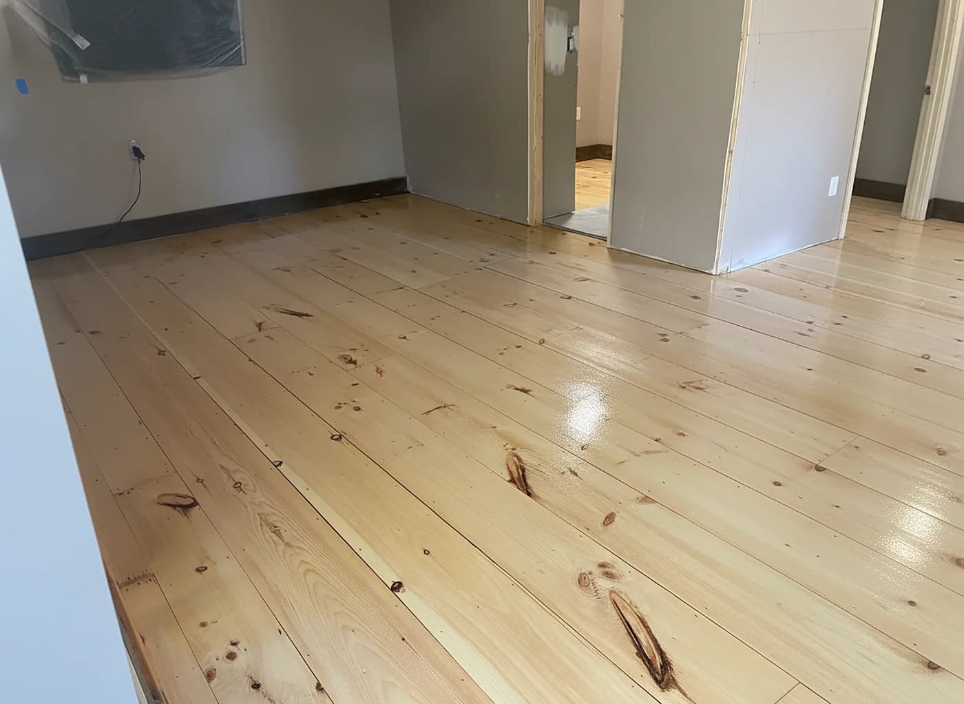 Sunlit wide-plank pine floor refinished in a Fairfield County home