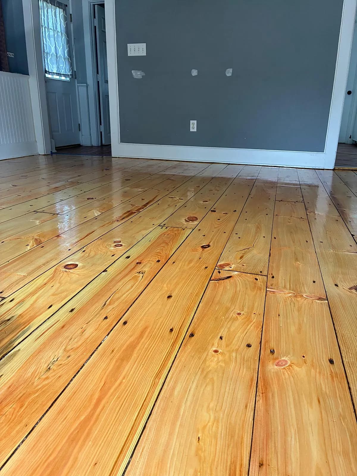 Wide-plank pine floor refinished with a natural glossy finish